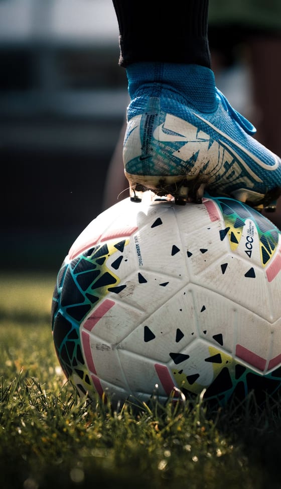A player resting a boot on a match ball